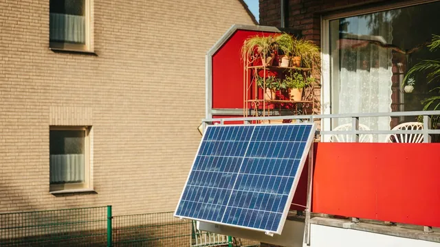 Zonnepaneel aan de balustrade van een stadsbalkon met planten